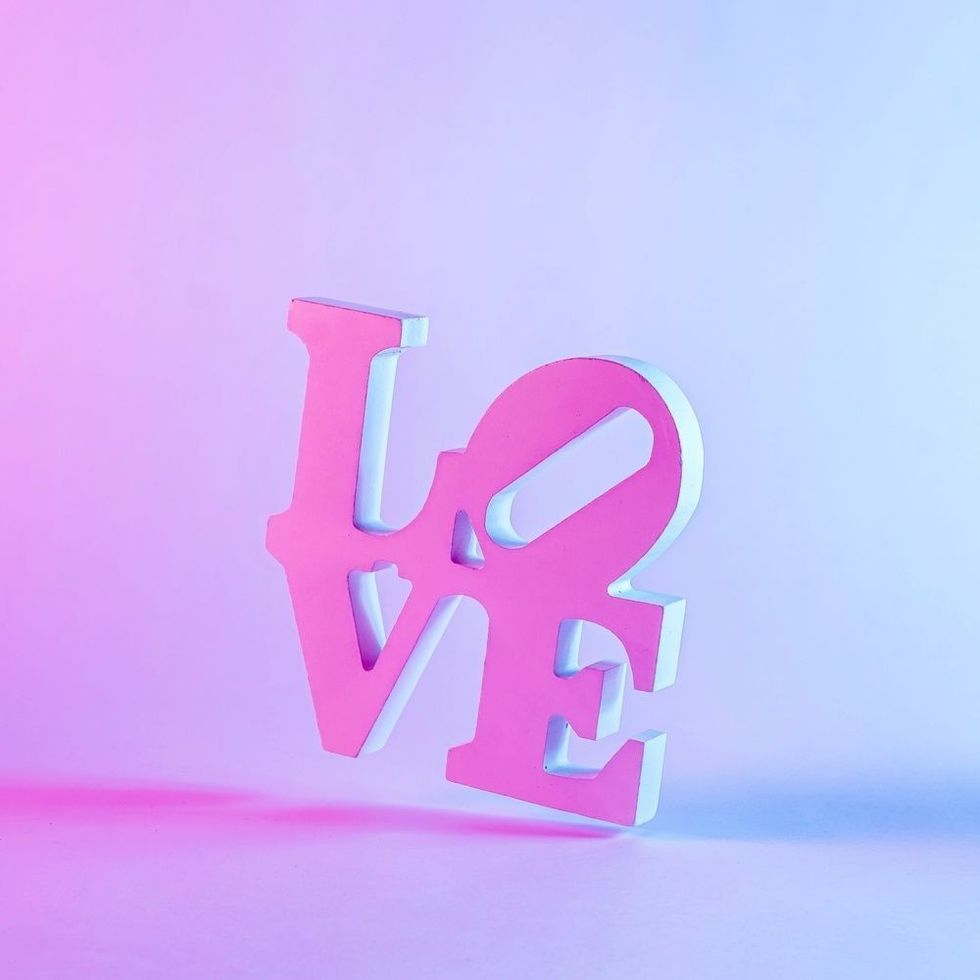 3d love word with shadow against pastel purple background