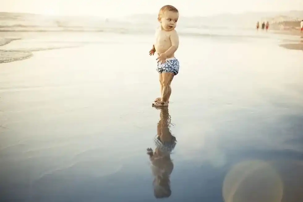 A baby boy enjoying on a beach