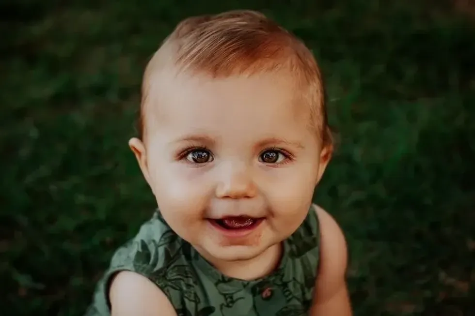 A baby boy smiling at the camera