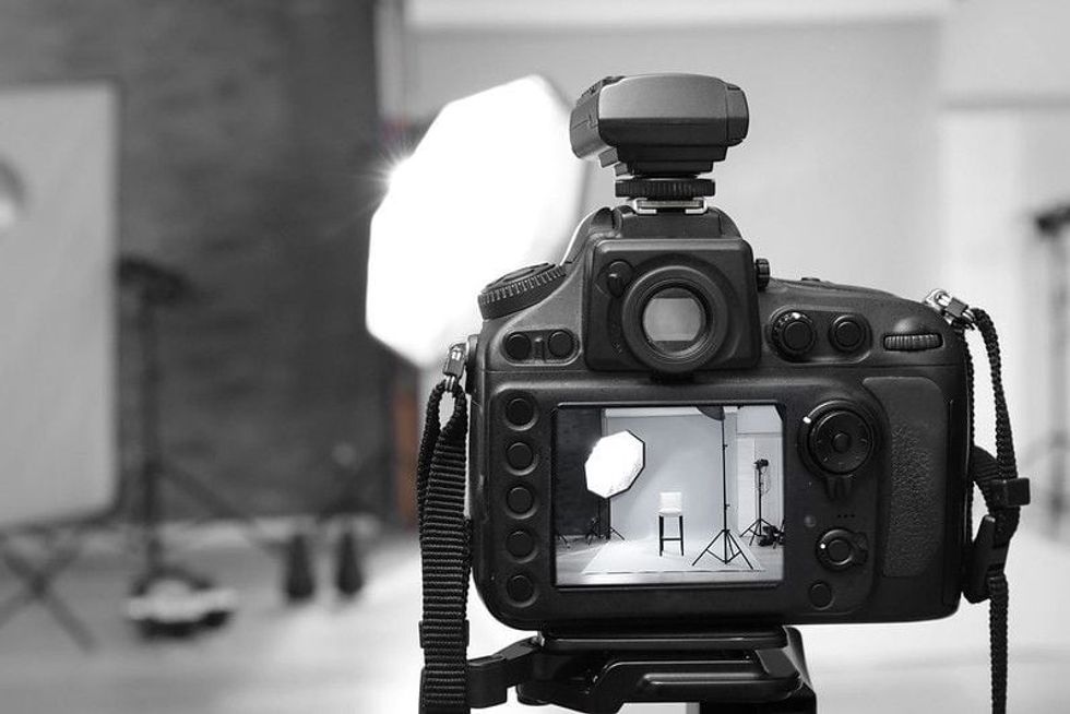 A black and white image of a camera displaying a picture of the background.