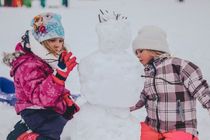 A boy and a girl playing in the snow