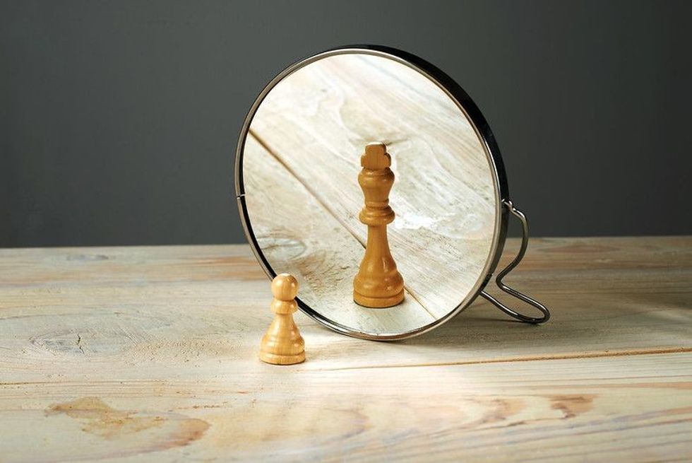 A chess pawn in front of mirror
