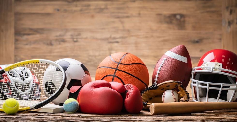 A collection of different sports items including balls, gloves, bats, racket and helmet.