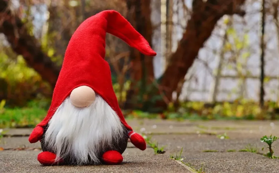 A cute elf toy wearing huge red cap