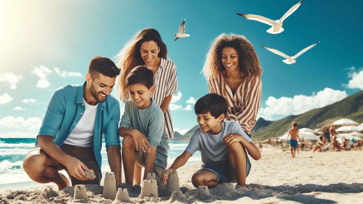  A family building a sandcastle and enjoying a school break vacation at a sunny beach.