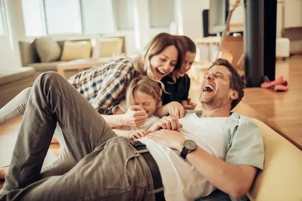 A family laughing together in their living room.