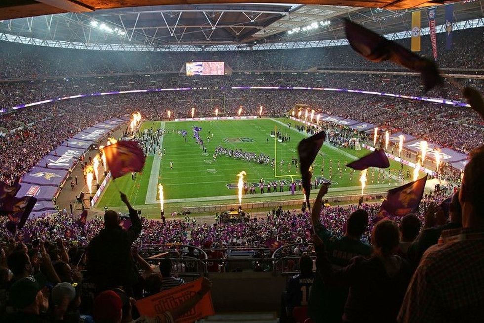 A football stadium showing numerous spectators and fireworks on display.