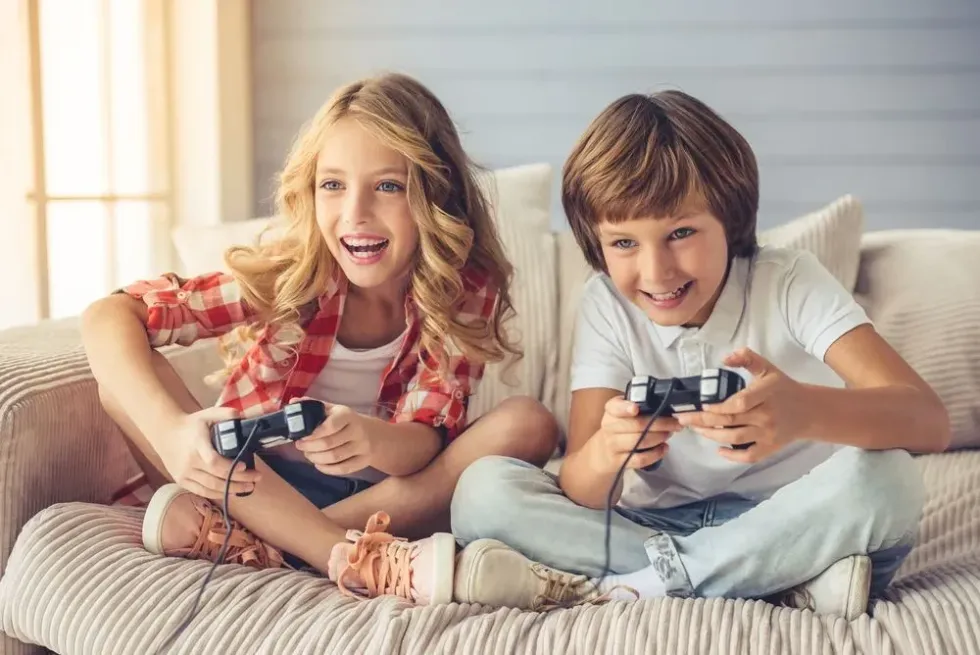 A girl and boy playing video game in their house