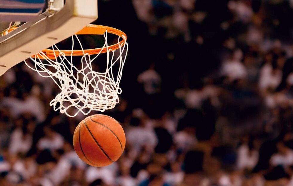 A goal being scored in a game of basketball