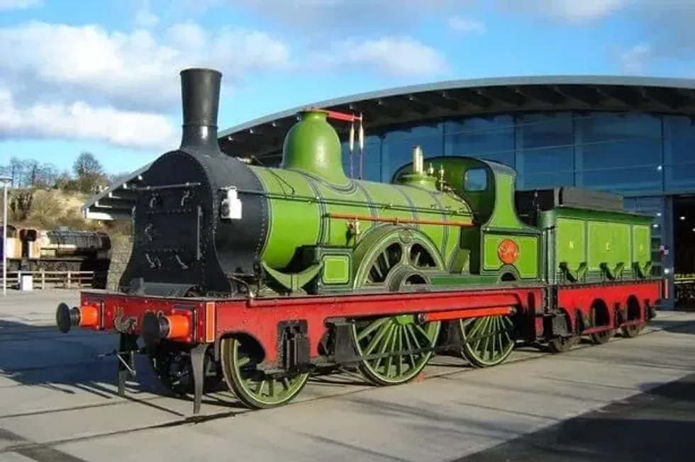 A green steam train outside Locomotion.