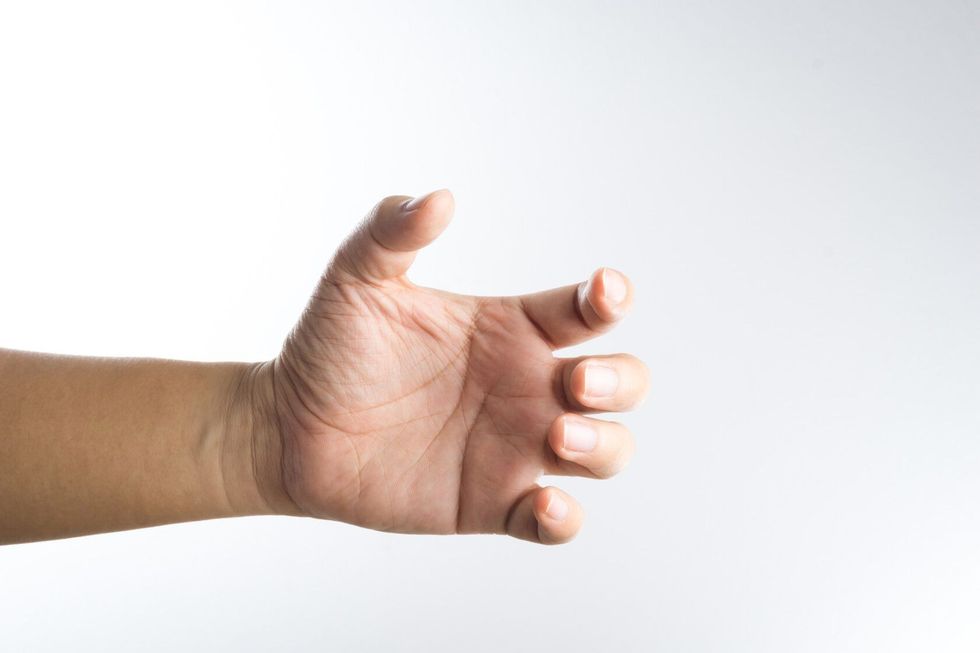 A hand holding something like a bottle on white background.