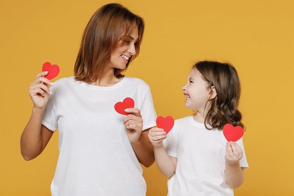 A happy woman in white t-shirt having fun with child