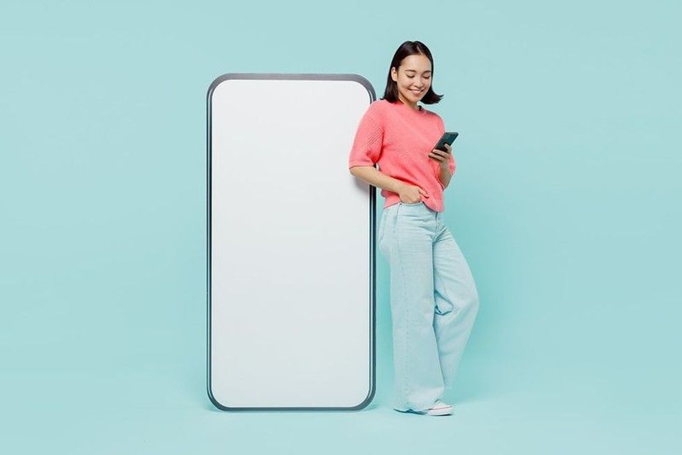 A happy woman standing next to life size mobile