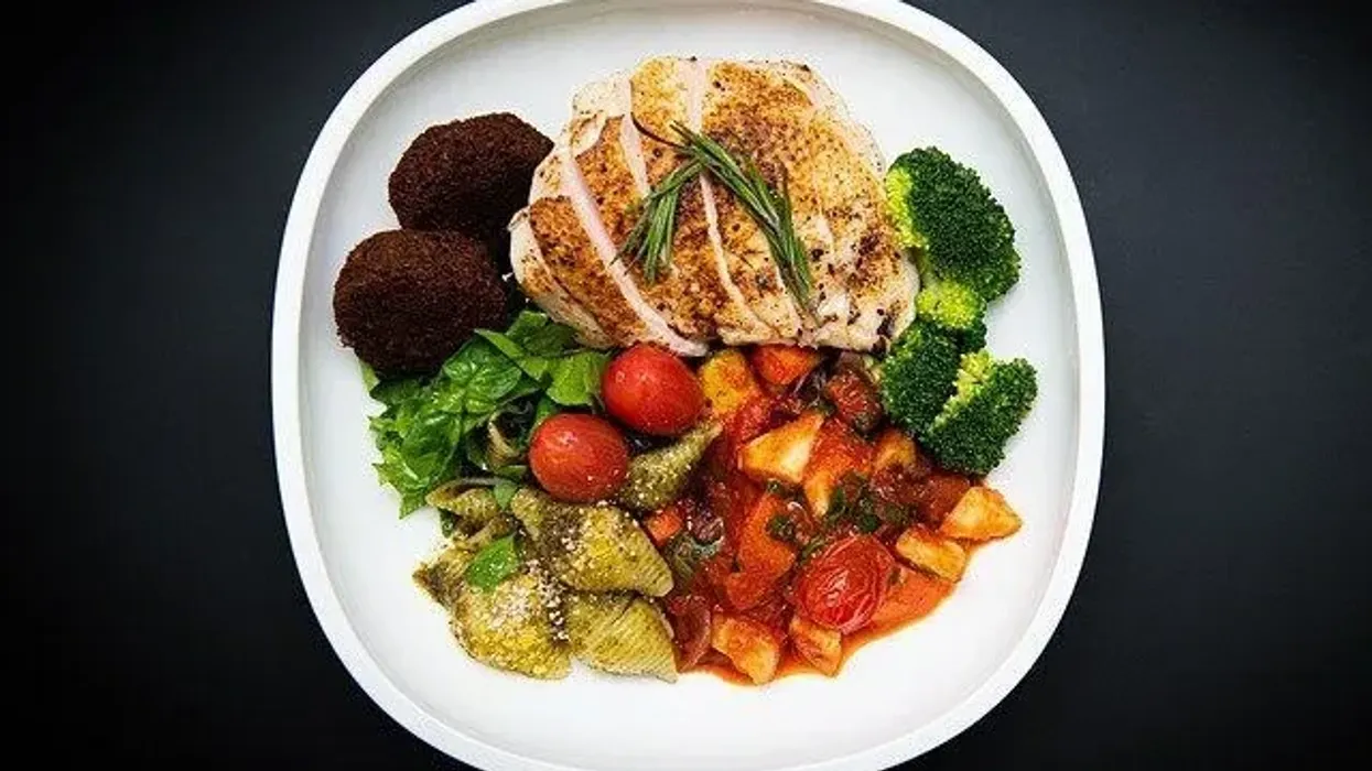 A healthy lunch plate with grilled chicken, falafel, mixed vegetables, and salad, perfect to accompany lunch quotes about the importance of a midday meal.