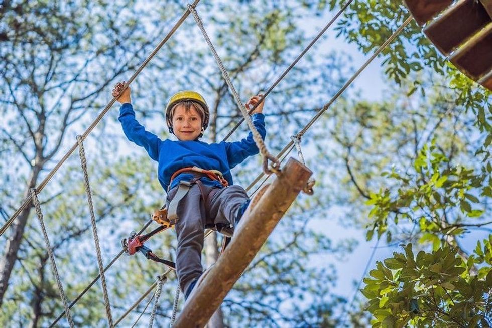 A healthy teenager school boy enjoying activity in a climbing adventure park