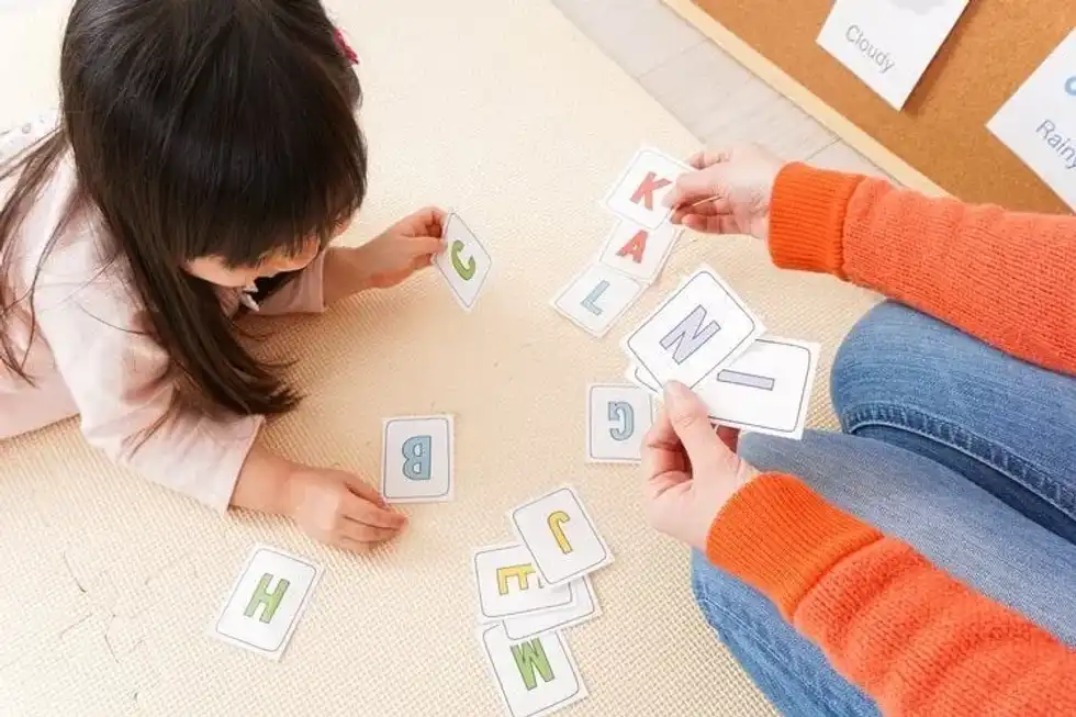 A little girl is learning alphabets