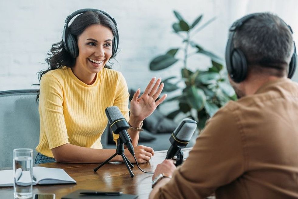 A male and female person recording a podcast.