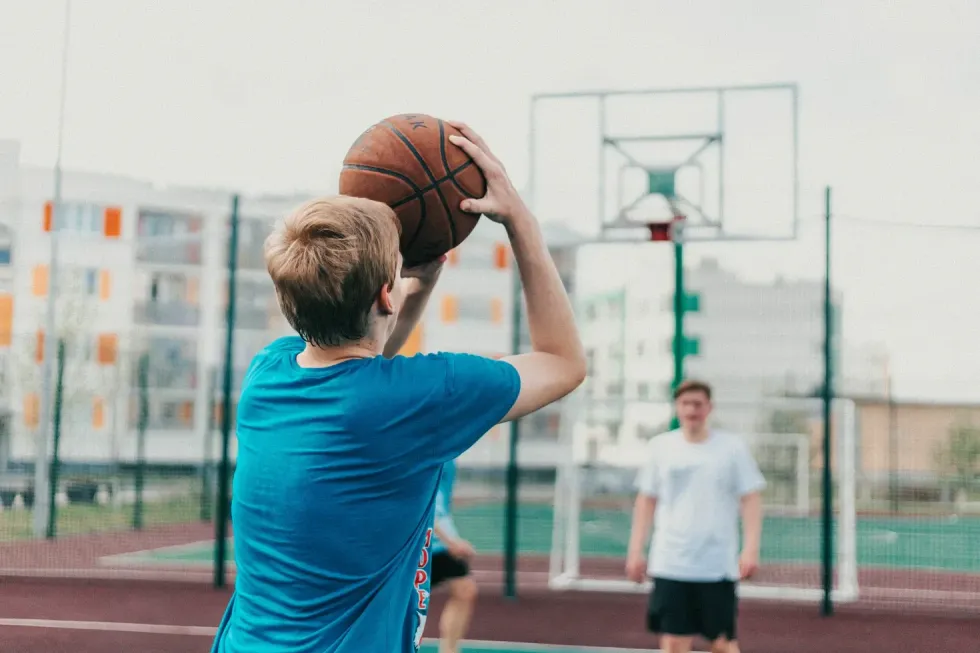 A man attempting to shoot a basketball into a net.