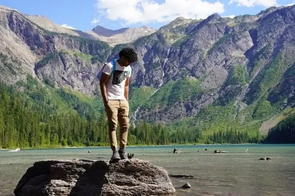A man standing on rock at  Avalanche Lake, Glacier National Park