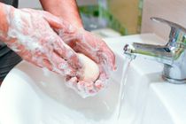 A man washes his hands with soap