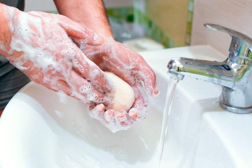 A man washes his hands with soap