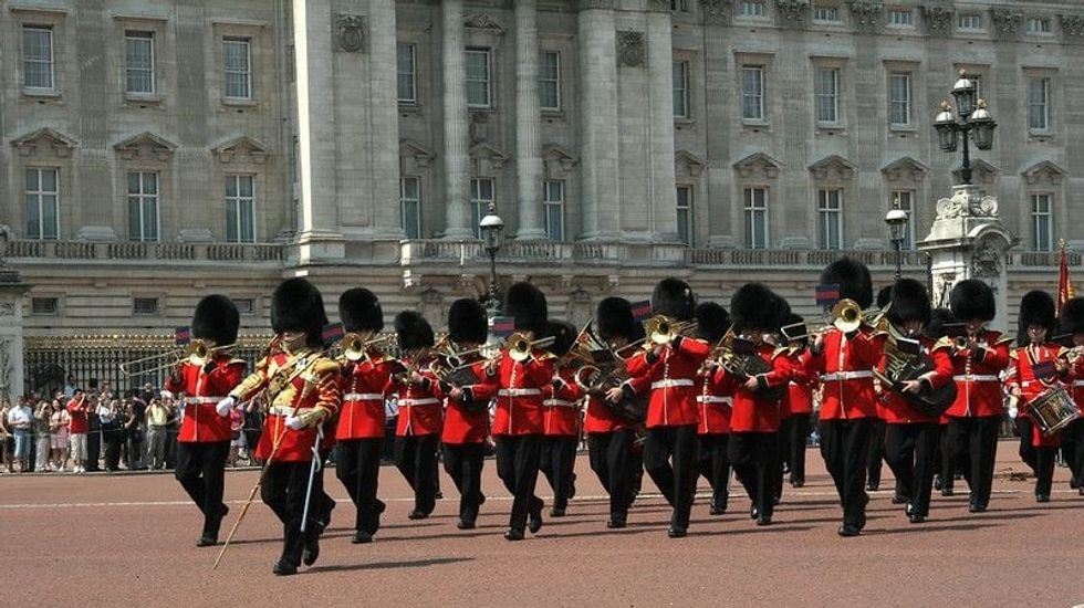 A marching band marching in front of Buckingham