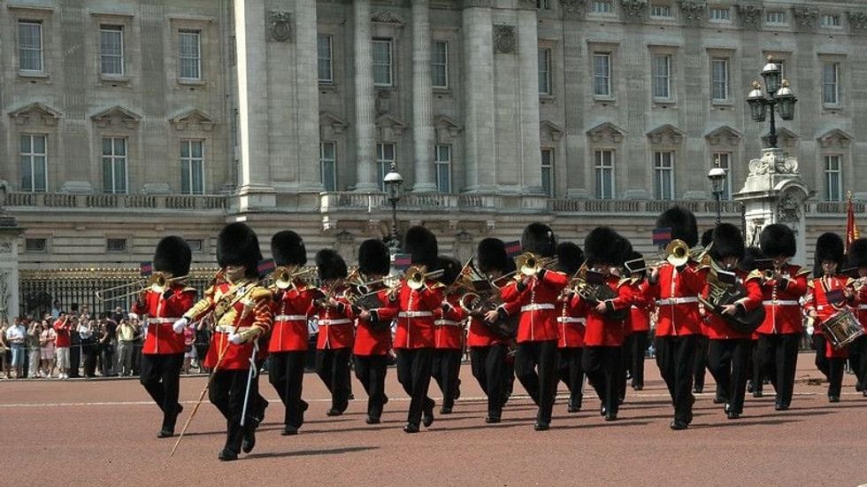 A marching band marching in front of Buckingham