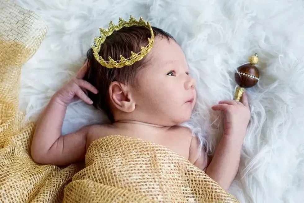 A newborn baby boy with a golden crown