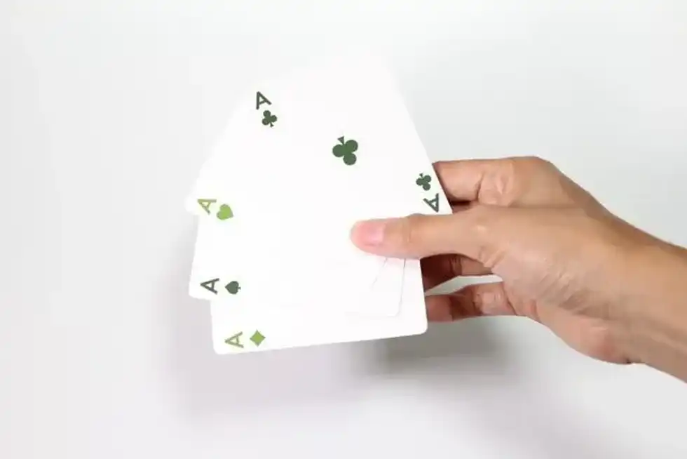 A person holding four ace cards