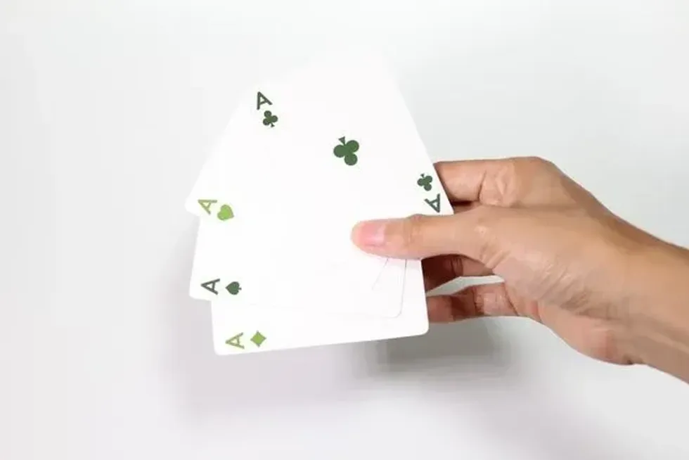 A person holding four ace cards