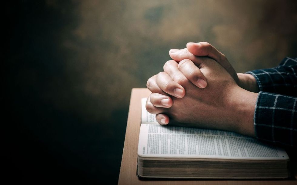 A person holding hands in prayer