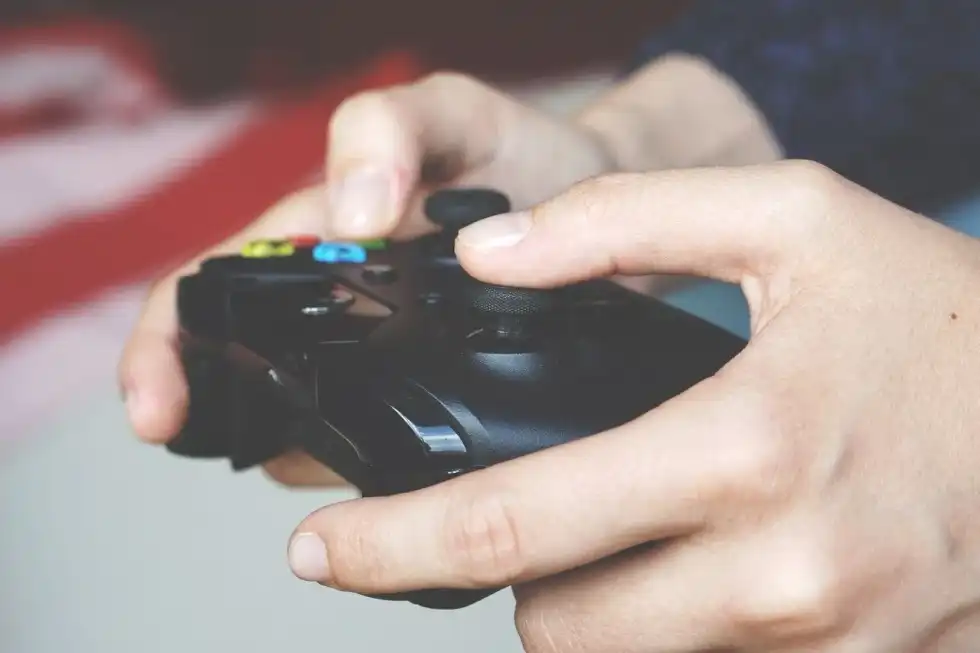 A person playing games with a black console
