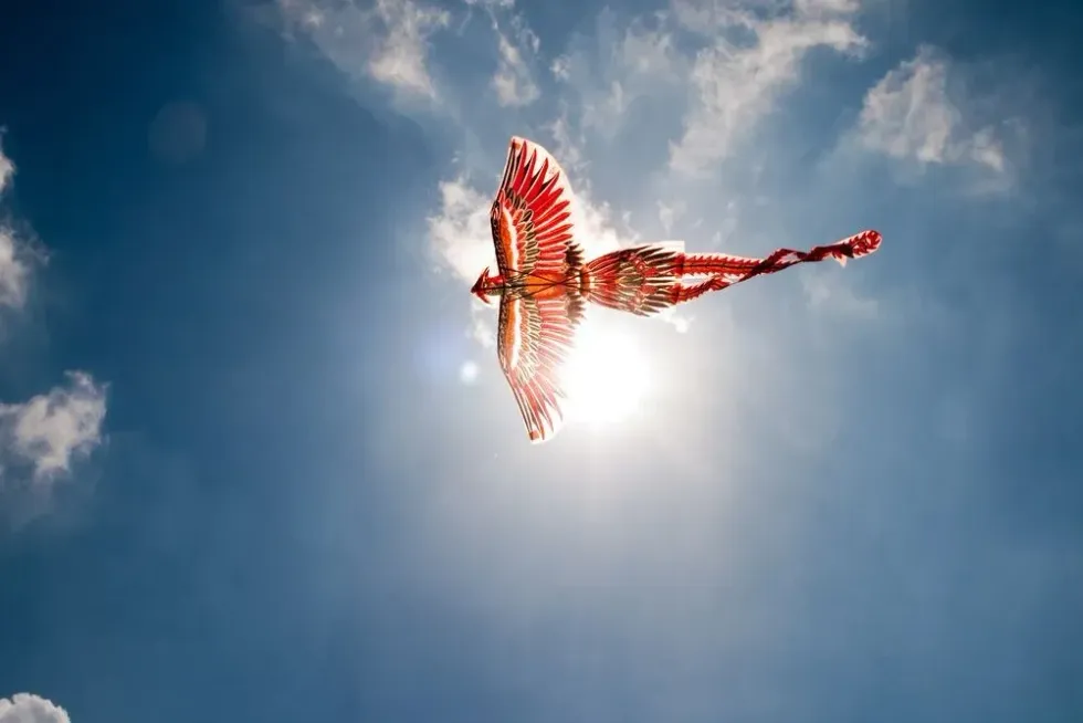A phoenix shaped kite flying in the blue sky