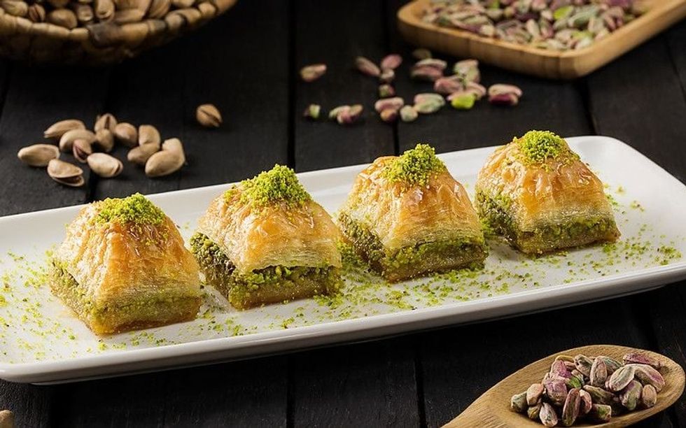 A plate of baklava garnished with pistachios offers a sweet glimpse into food trivia.