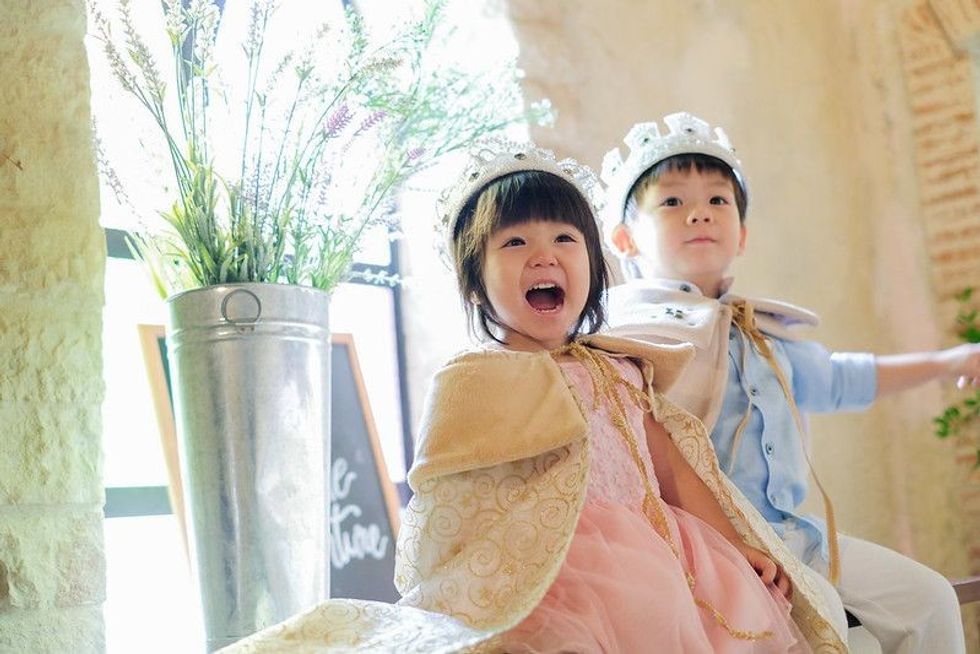 A princess smiles and sits with a prince in a castle.