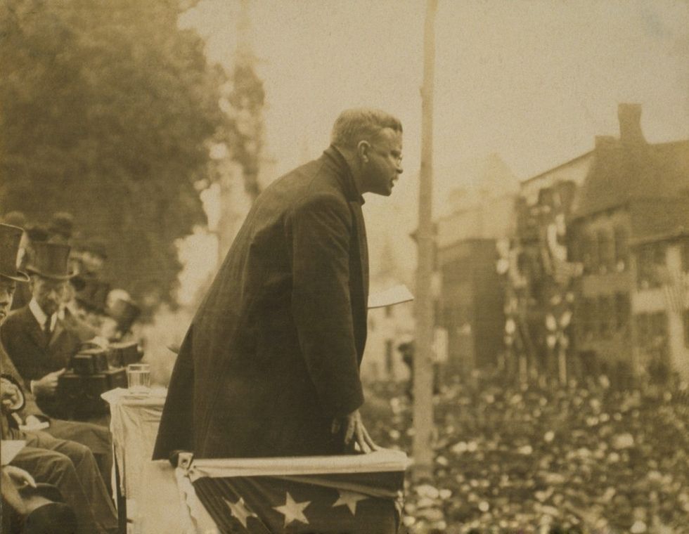 A sepia-toned image of President Theodore Roosevelt speaking to a crowd in 1906.