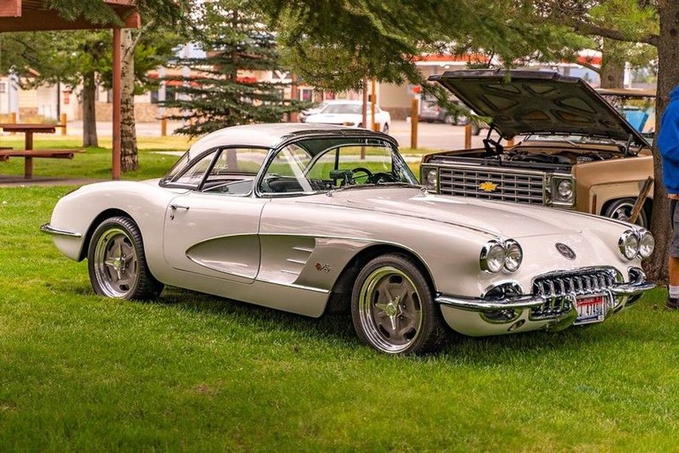 A silver Chevrolet Corvette parked on a grassy lawn