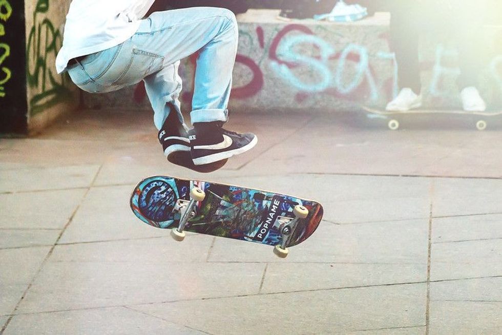A skateboarder doing a trick with a skateboard at a skate park.