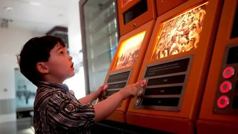 A small boy playing on one of the interactive learning machines at the National Waterfront Museum.