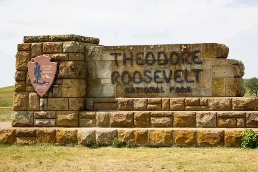 A stone sign for Theodore Roosevelt National Park with the National Park Service emblem, symbolizing Theodore Roosevelt facts.