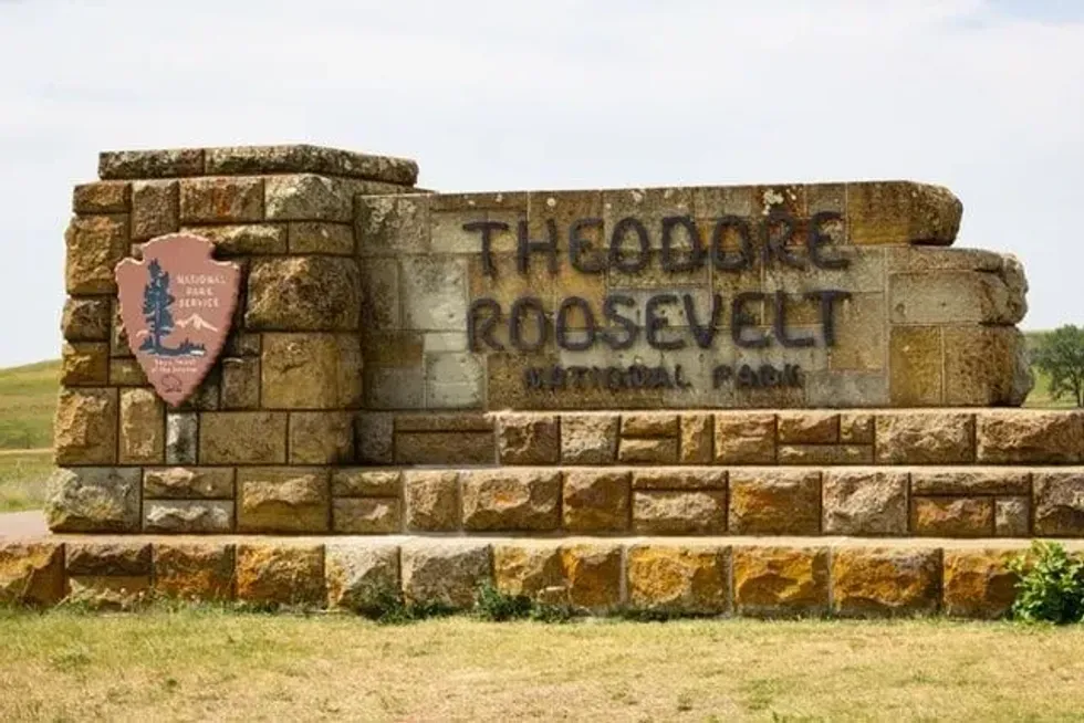 A stone sign for Theodore Roosevelt National Park with the National Park Service emblem, symbolizing Theodore Roosevelt facts.