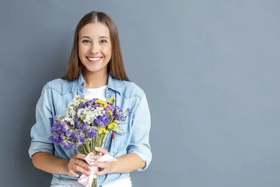 A teenage girl celebrating her birthday with flowers.