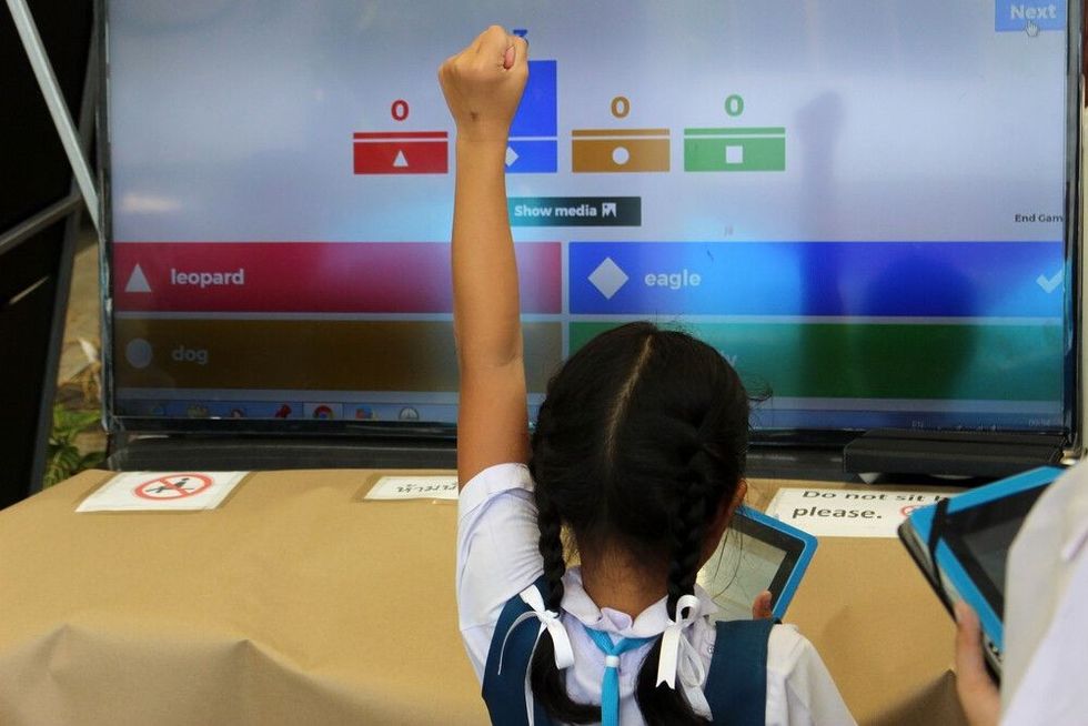 A Thai primary school girl celebrates her correct answer during a game of "Kahoot!", an online game based learning platform used as educational technology.