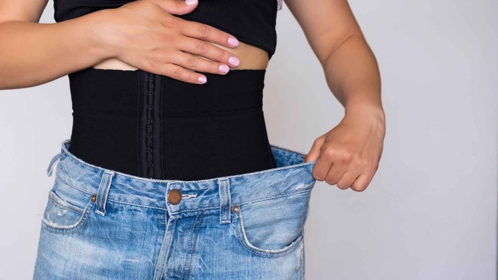 A woman fastens a corset for figure correction