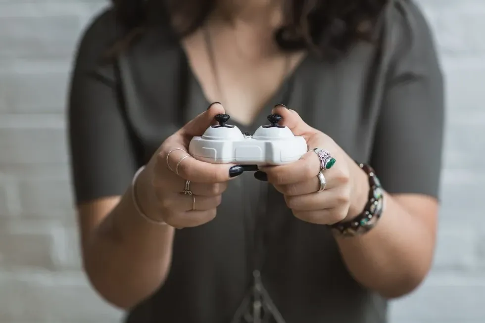 A woman playing video games with white console