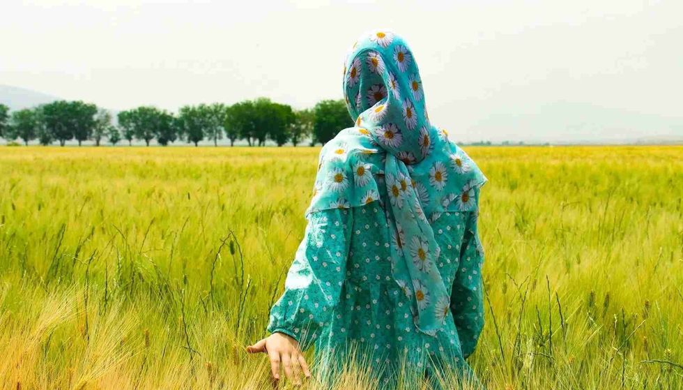 A woman walking in the green field 