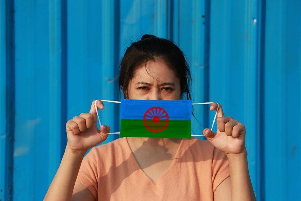 A woman with the Romani people flag on a hygienic mask.