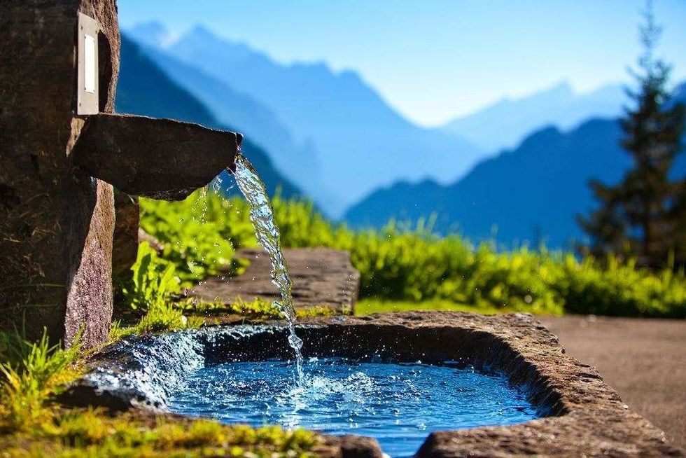 A Wooden standpipe pouring with fresh cold water.