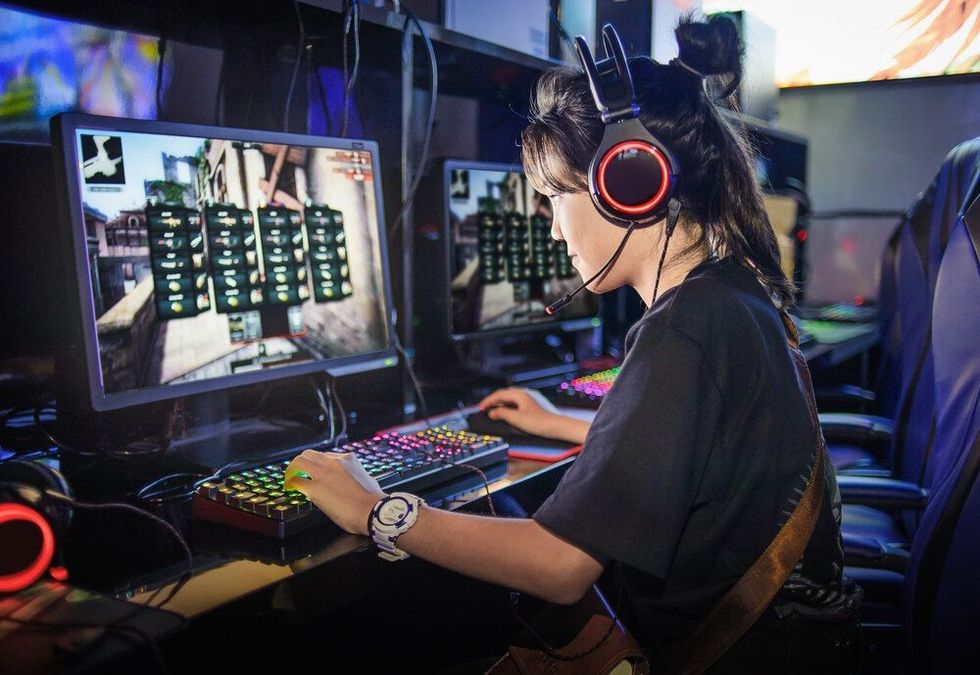 A young girl playing computer games in internet cafe.