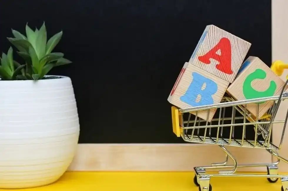 ABC blocks with English letters in a toy shopping cart.